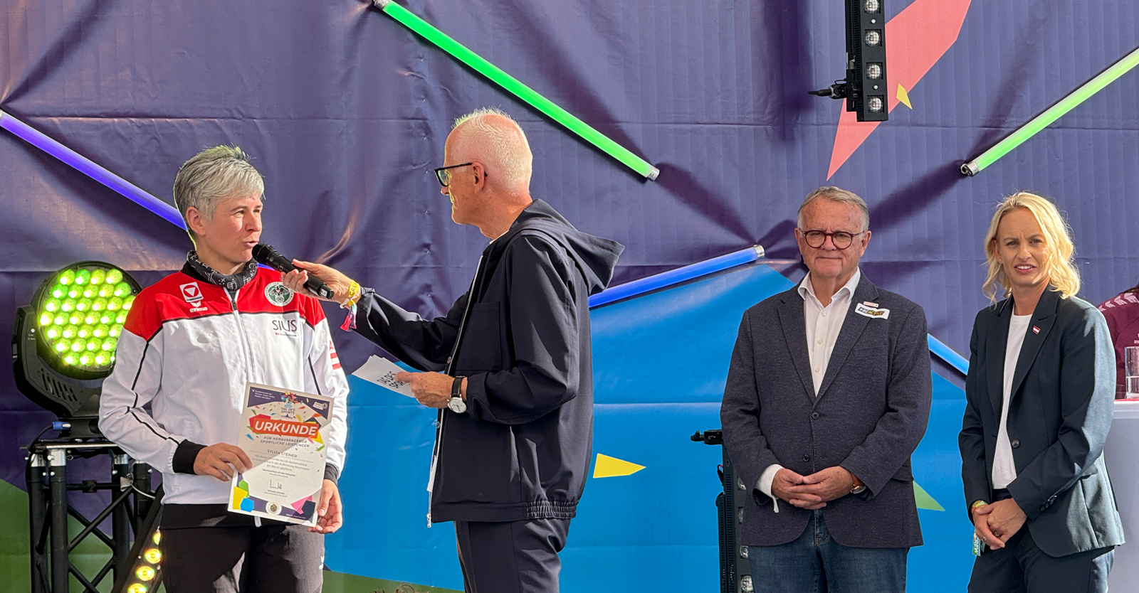 Sylvia Steiner (li.) bei ihrer Ehrung auf der Hauptbühne durch Sport-Staatssekretärin Michaela Schmidt (re.) © Neururer